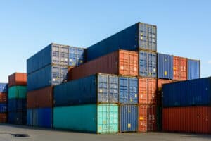 Dozens of metal containers stacked in a shipping yard